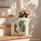 White canvas tote bag featuring humorous "Oops I Got Another Plant Goose" design, perfect for gardening humor fans.