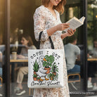 White canvas tote bag featuring humorous "Oops I Got Another Plant Goose" design by OrnamentallyYou, perfect for gardening lovers.