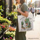White canvas tote bag featuring humorous "Oops I Got Another Plant" goose design by OrnamentallyYou, perfect for gardening humor.