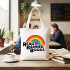 White canvas tote bag featuring a rainbow design with the phrase "Read Banned Books," ideal for book lovers and shoppers.