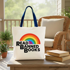 White Canvas Tote Bag by OrnamentallyYou featuring a rainbow design with "Read Banned Books" for book lovers and shoppers.