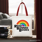 White canvas tote bag by OrnamentallyYou featuring a rainbow design and "Read Banned Books" message, perfect for book lovers.