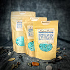 Small jar of Parlour of Wonders Banishing Bath Crystals with colorful crystals for relaxing bath experience.