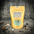 Small jar of Parlour of Wonders Santa Muerte Bath Crystals with colorful crystals and label, ideal for relaxing bath rituals.