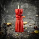 Black beeswax candle with intricate binding knot design, used for strengthening bonds and protection in spiritual rituals.