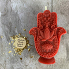 Blue beeswax Hamsa hand spell candle with evil eye design for protection and blessing, from Parlour of Wonders.