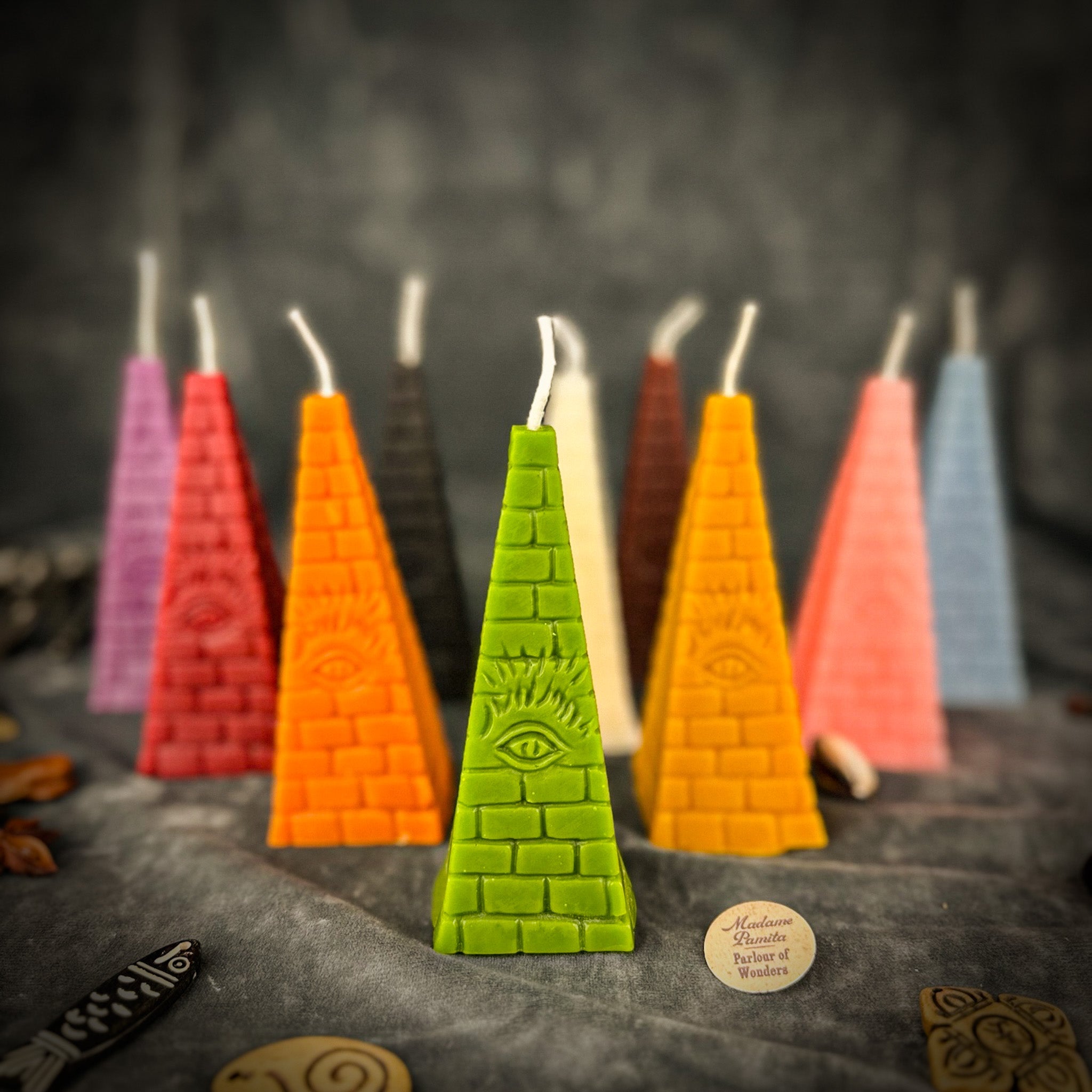 Green beeswax candle with an all-seeing eye pyramid design, symbolizing abundance, prosperity, and intuition from Parlour of Wonders.