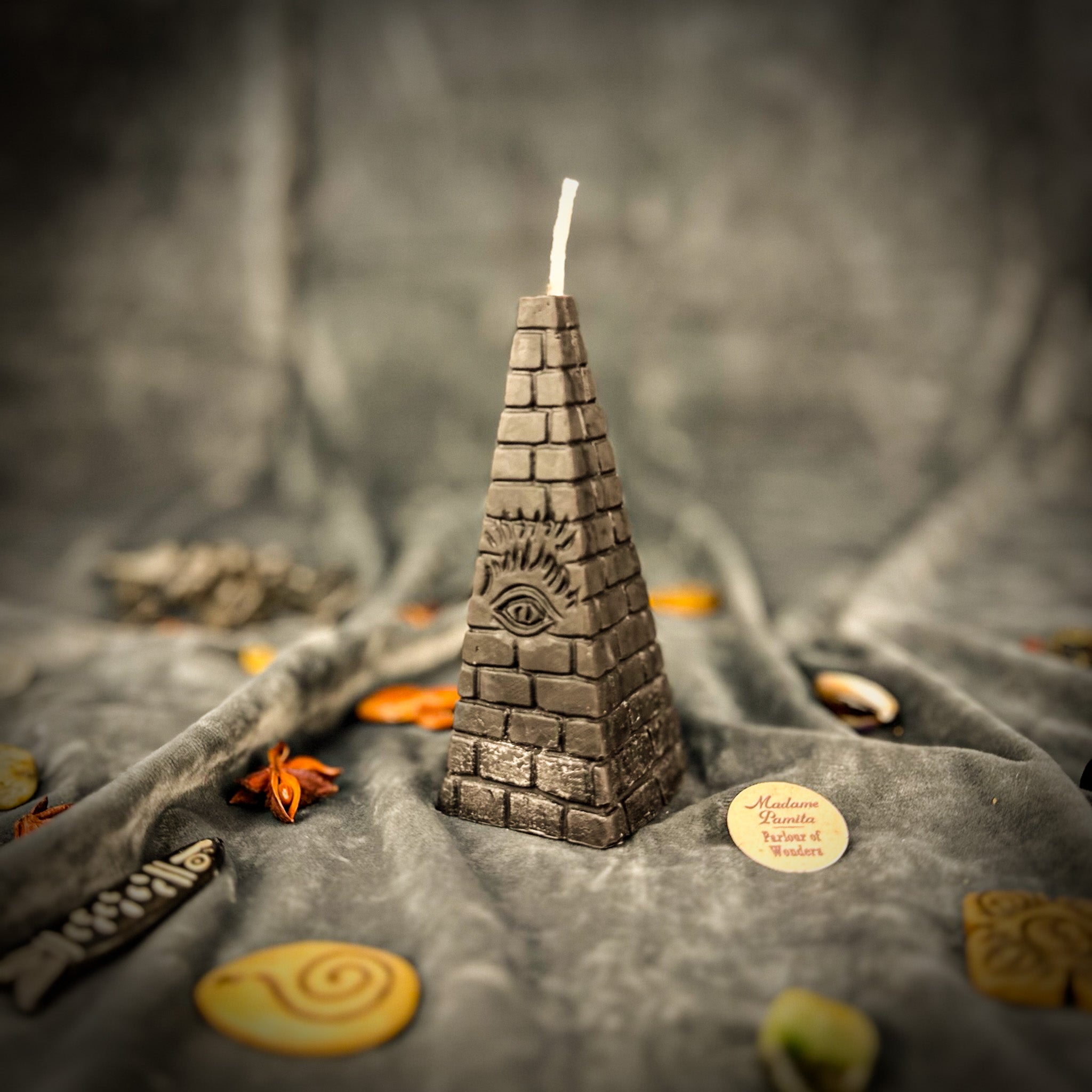 Green beeswax candle with an all-seeing eye pyramid design, symbolizing abundance, prosperity, and intuition.