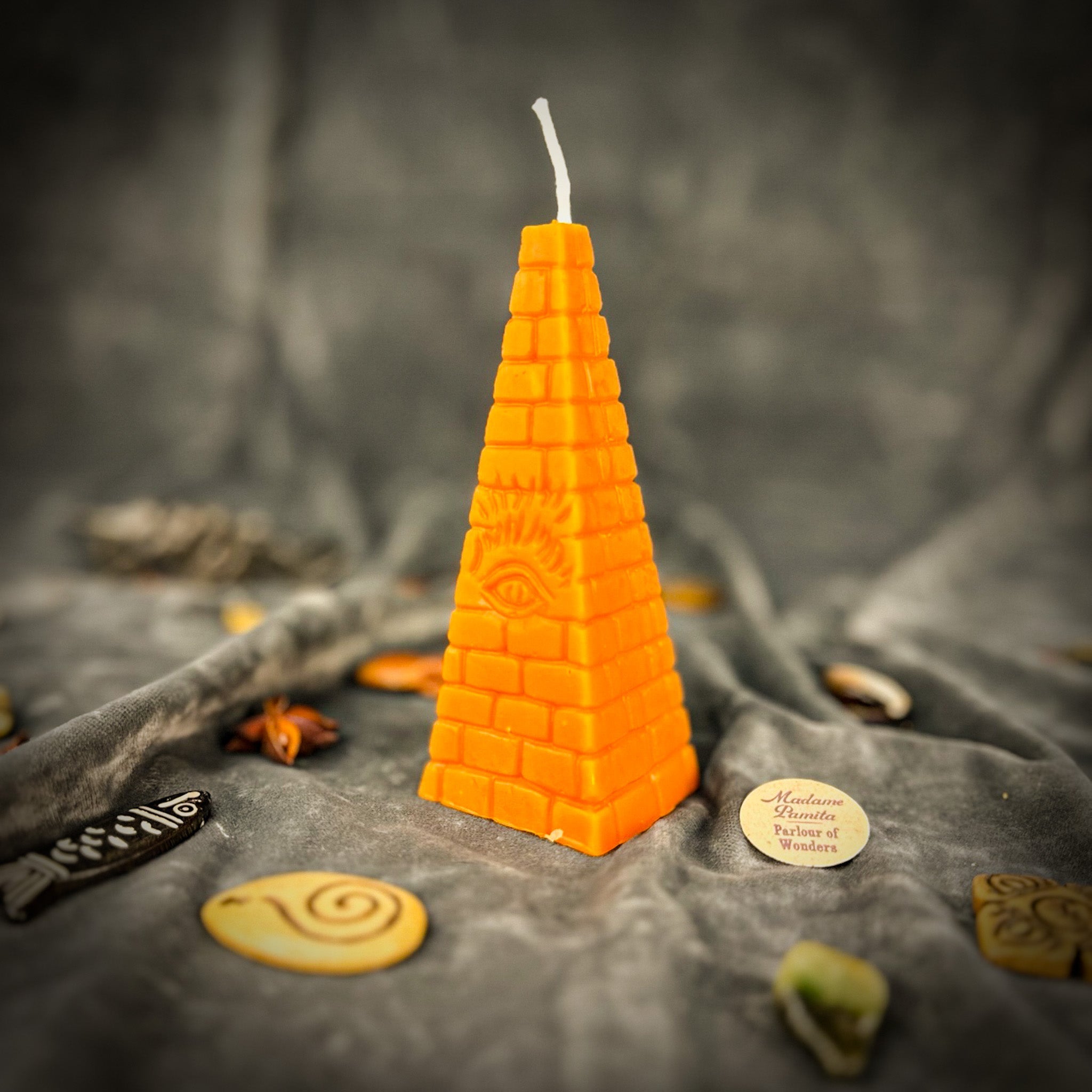 Green beeswax candle with an all-seeing eye pyramid design for abundance, prosperity, and intuition by Parlour of Wonders.