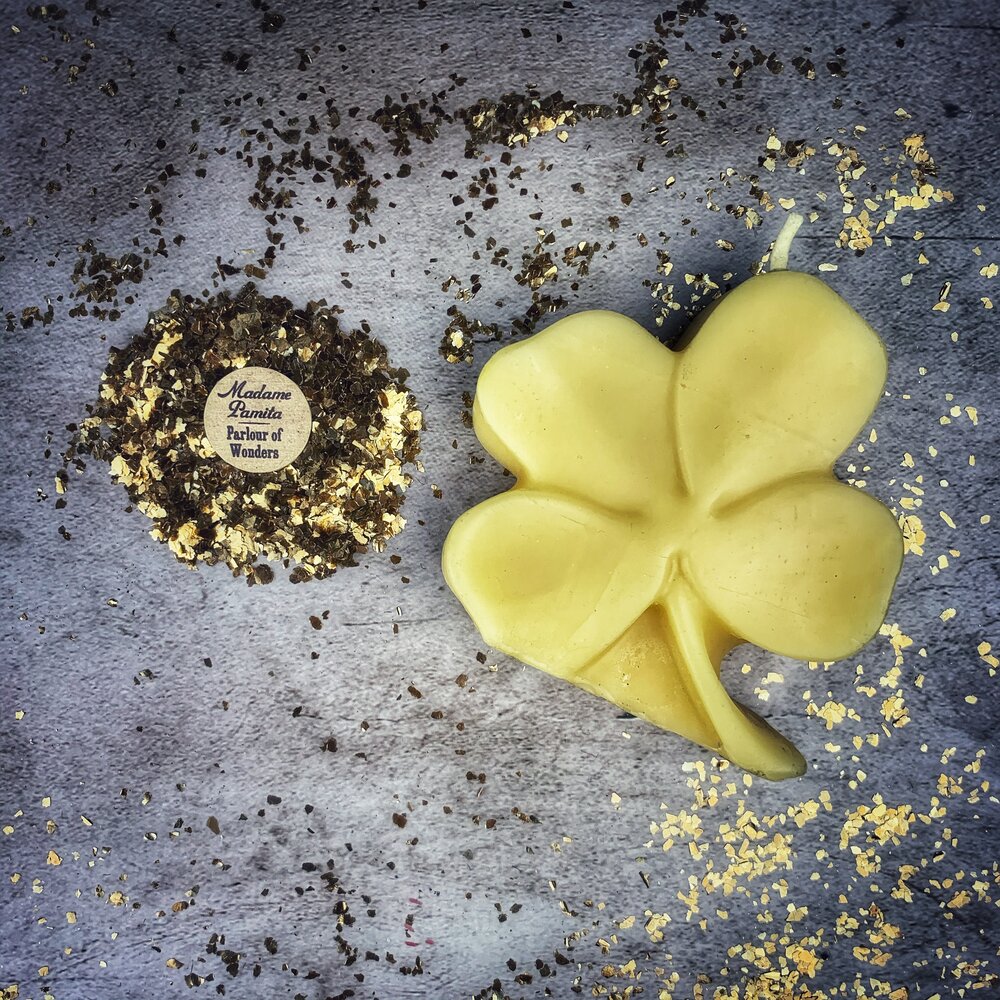 Green beeswax candle with a four-leaf clover design, symbolizing good fortune and luck, by Parlour of Wonders.