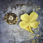 Green beeswax candle with a four-leaf clover design, symbolizing good fortune and luck, by Parlour of Wonders.