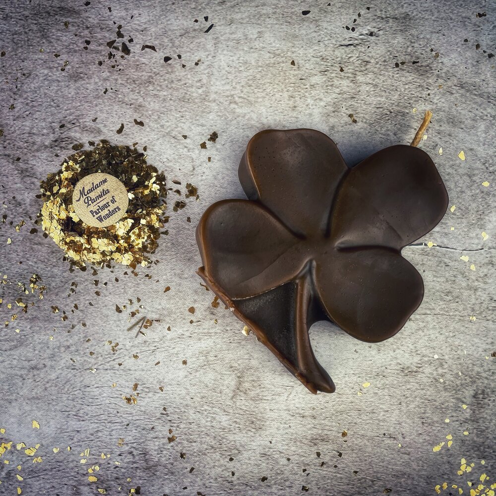 Green beeswax candles shaped like four-leaf clovers from Parlour of Wonders, symbolizing good luck and prosperity.