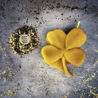 Green beeswax candle with a four-leaf clover design, symbolizing luck and good fortune, from Parlour of Wonders.