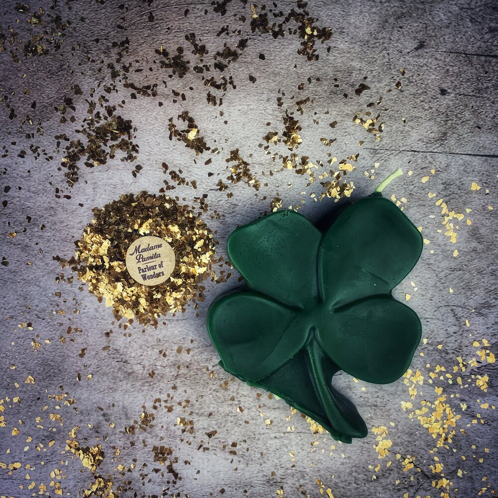 Green beeswax candle with four-leaf clover design by Parlour of Wonders, symbolizing luck and good fortune.
