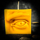 Beeswax Ex-Voto Eye Spell Candle by Parlour of Wonders for vision, clairvoyance, and being seen, with orange wax and eye design.