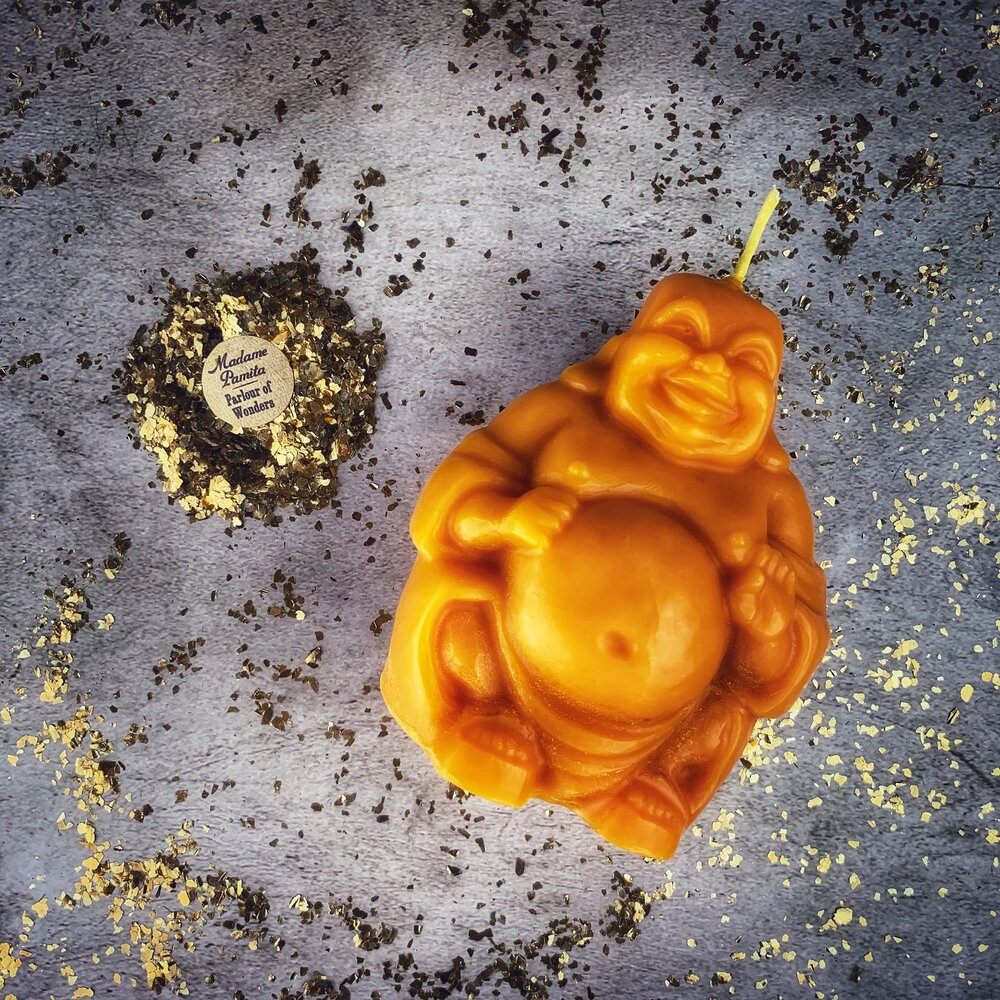 Beeswax Laughing Buddha spell candle by Parlour of Wonders, orange beeswax candle for wealth, luck, and prosperity magic.