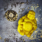 Beeswax Laughing Buddha spell candle by Parlour of Wonders, orange beeswax candle for wealth, luck, and prosperity magic.