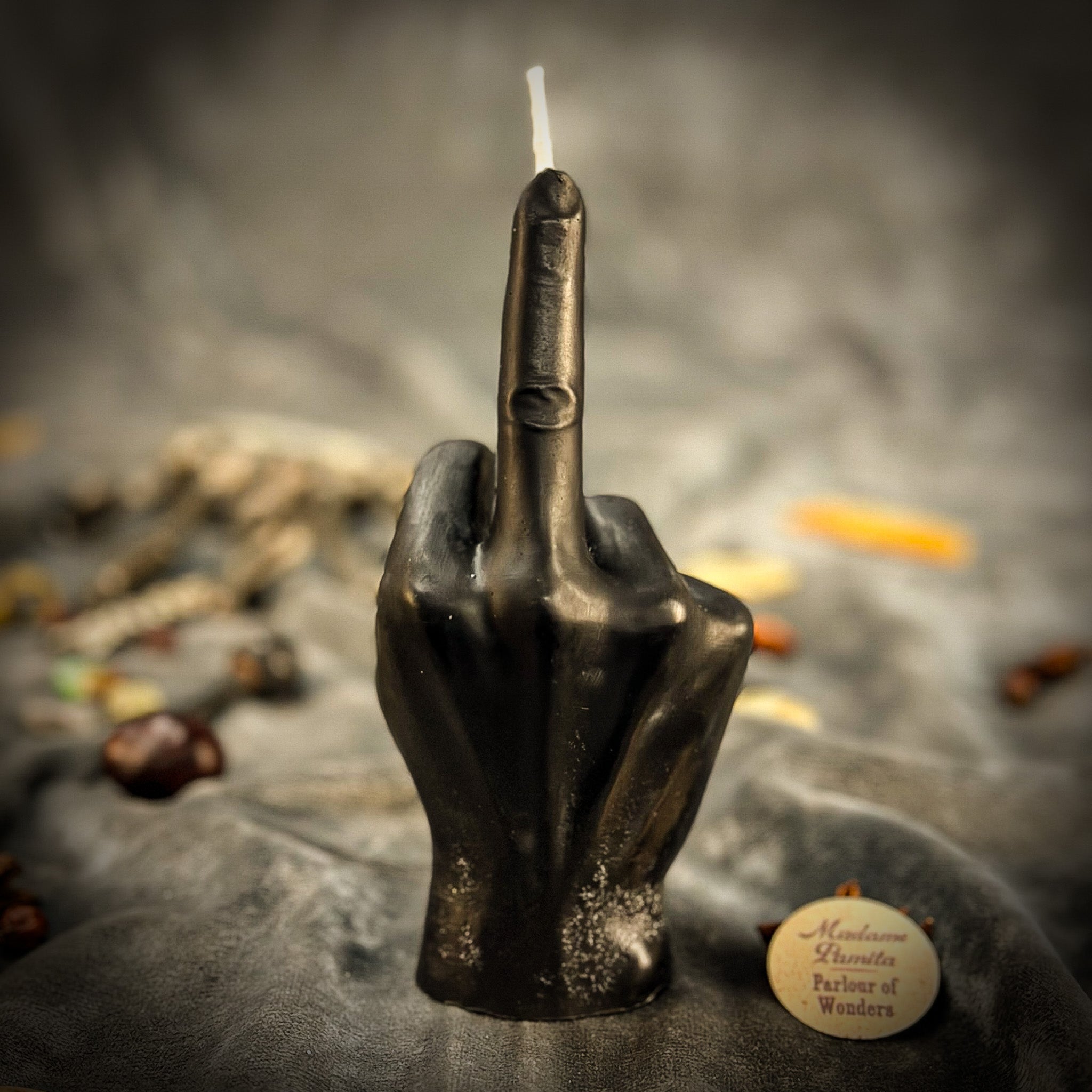 Orange beeswax candle by Parlour of Wonders featuring a middle finger design for banishing, boundaries, and empowerment spells.