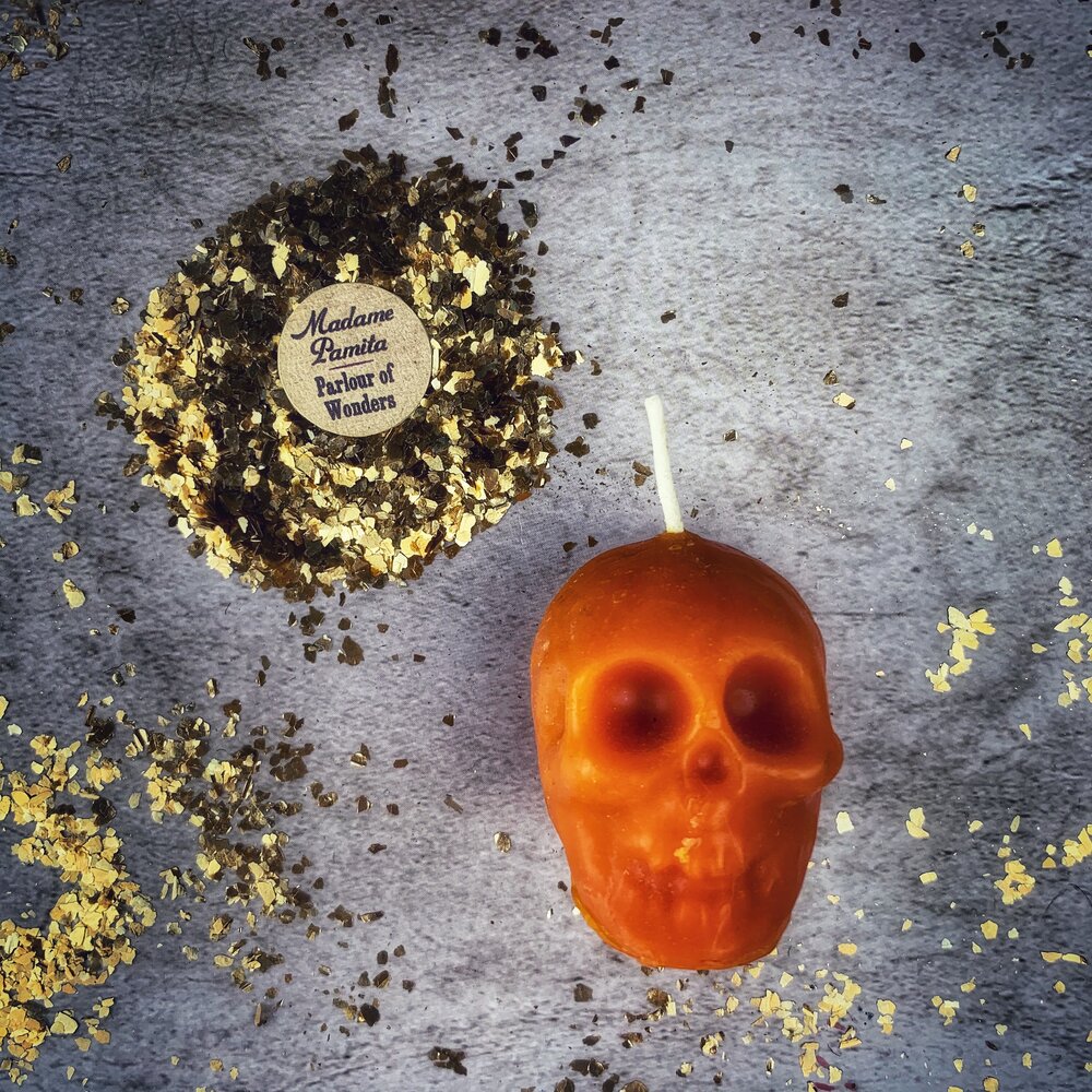Small beeswax skull spell candle by Parlour of Wonders featuring orange color and intricate design for mind influence and ancestral wisdom magic.