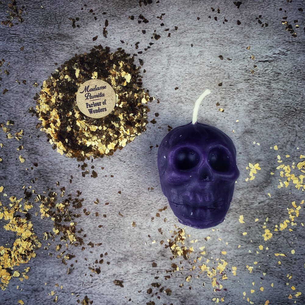 Small beeswax skull candle with orange accents, designed for mind influence and ancestral wisdom magic by Parlour of Wonders.