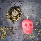 Small beeswax skull spell candle with orange coloration, designed for mind influence and ancestral wisdom magic.