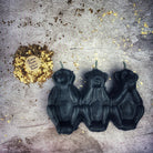 Red beeswax candle featuring three wise monkeys design, symbolizing silence, jealousy, and protection with mystical charm.