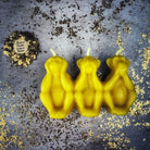Red beeswax candle featuring three wise monkeys design for protection, silence, and stopping gossip, by Parlour of Wonders.