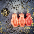 Red beeswax candle featuring three wise monkeys symbol, used for stopping jealousy, gossip, and silencing enemies, by Parlour of Wonders.