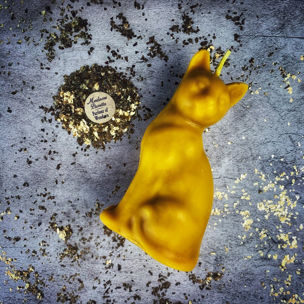 Red beeswax lucky cat spell candle by Parlour of Wonders for fast action and manifestation magic, featuring intricate cat design.