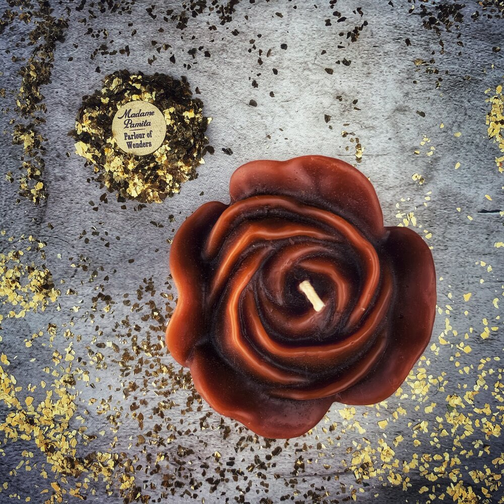 Red beeswax candle with rose design from Parlour of Wonders, used for love and soulmate magic rituals.