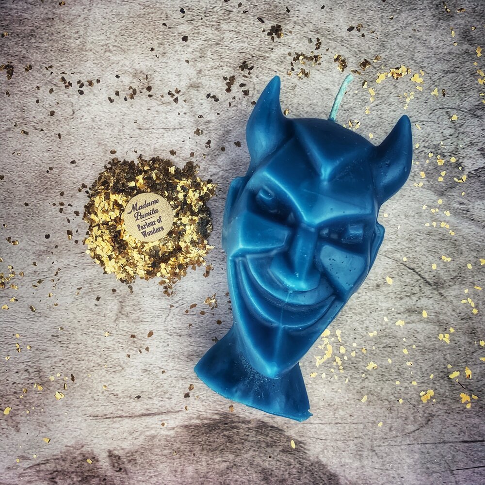 Red beeswax candle from Parlour of Wonders featuring intricate devil run spell design for banishing evil and invoking trickster magic.
