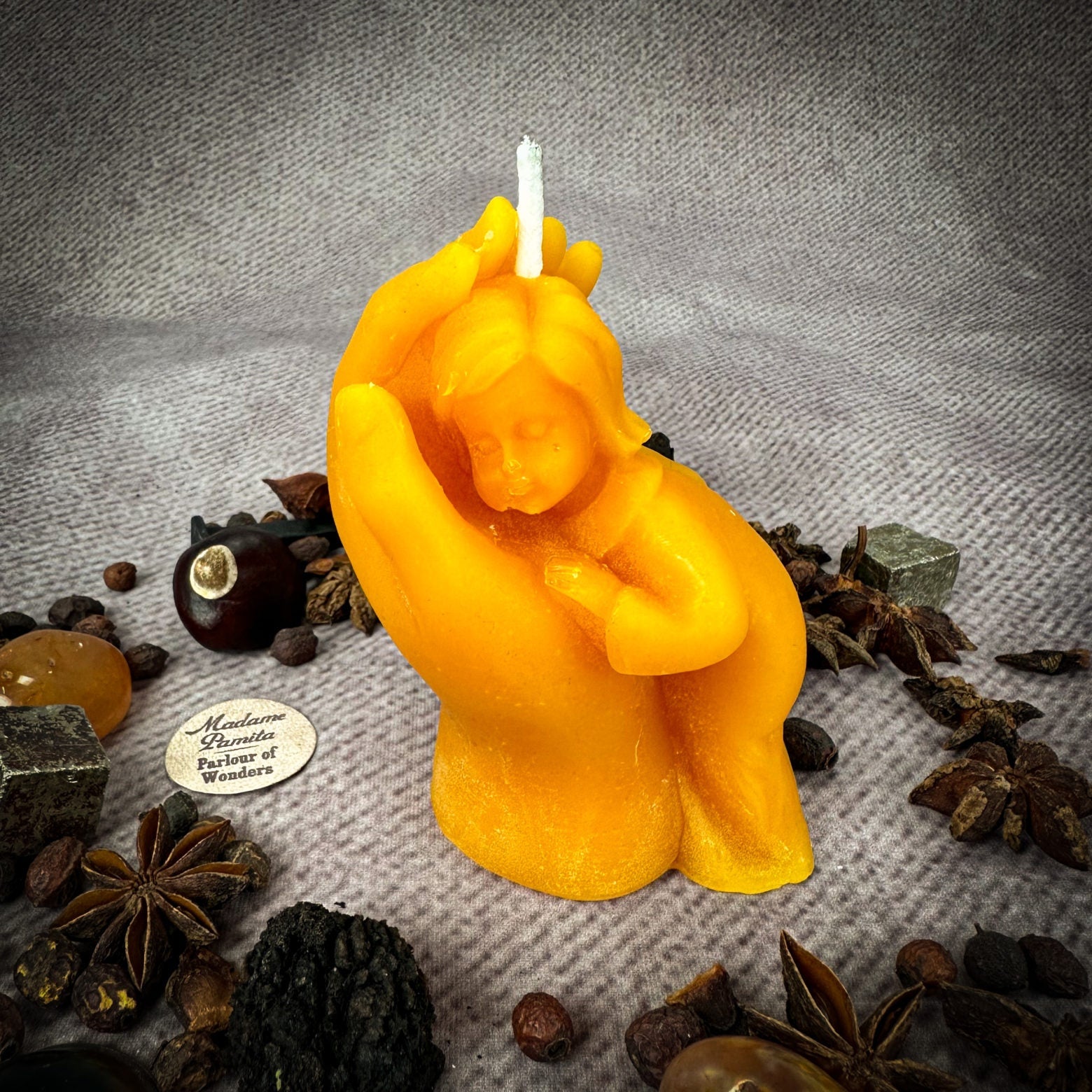 Yellow beeswax candle featuring a mother and child design, symbolizing protection, fertility, and family blessings.