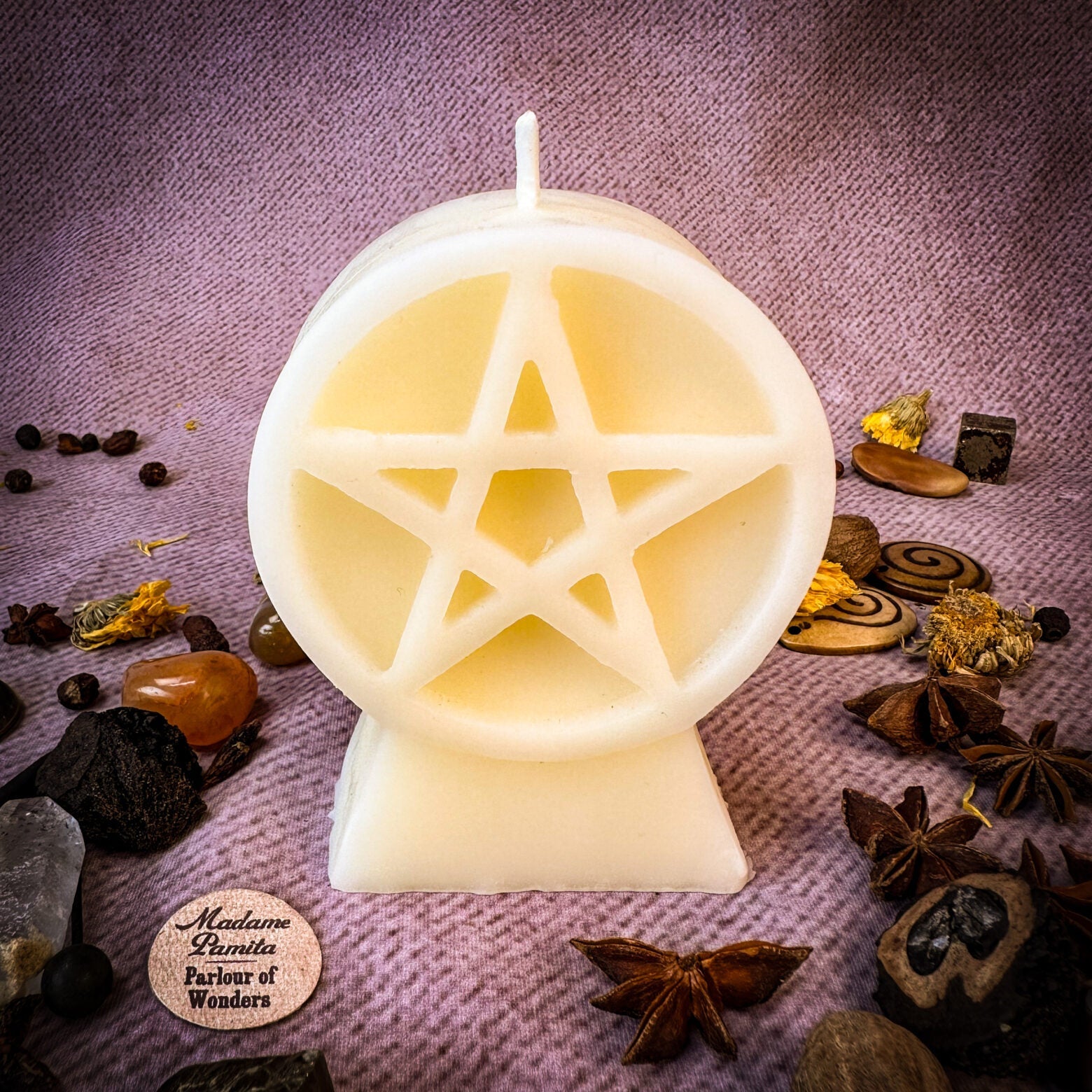 Yellow beeswax candle with pentacle of protection symbol, representing five elements and spiritual safety for spell work.