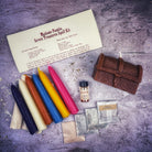 Parlour of Wonders Seven Treasures Candle Spell Kit with yellow candles for blessings and abundance, featuring various herbs and charms.