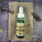 Bottle of Abundant Prosperity Oil by Madame Pamita from Parlour of Wonders, with a label featuring mystical symbols and a dark glass bottle