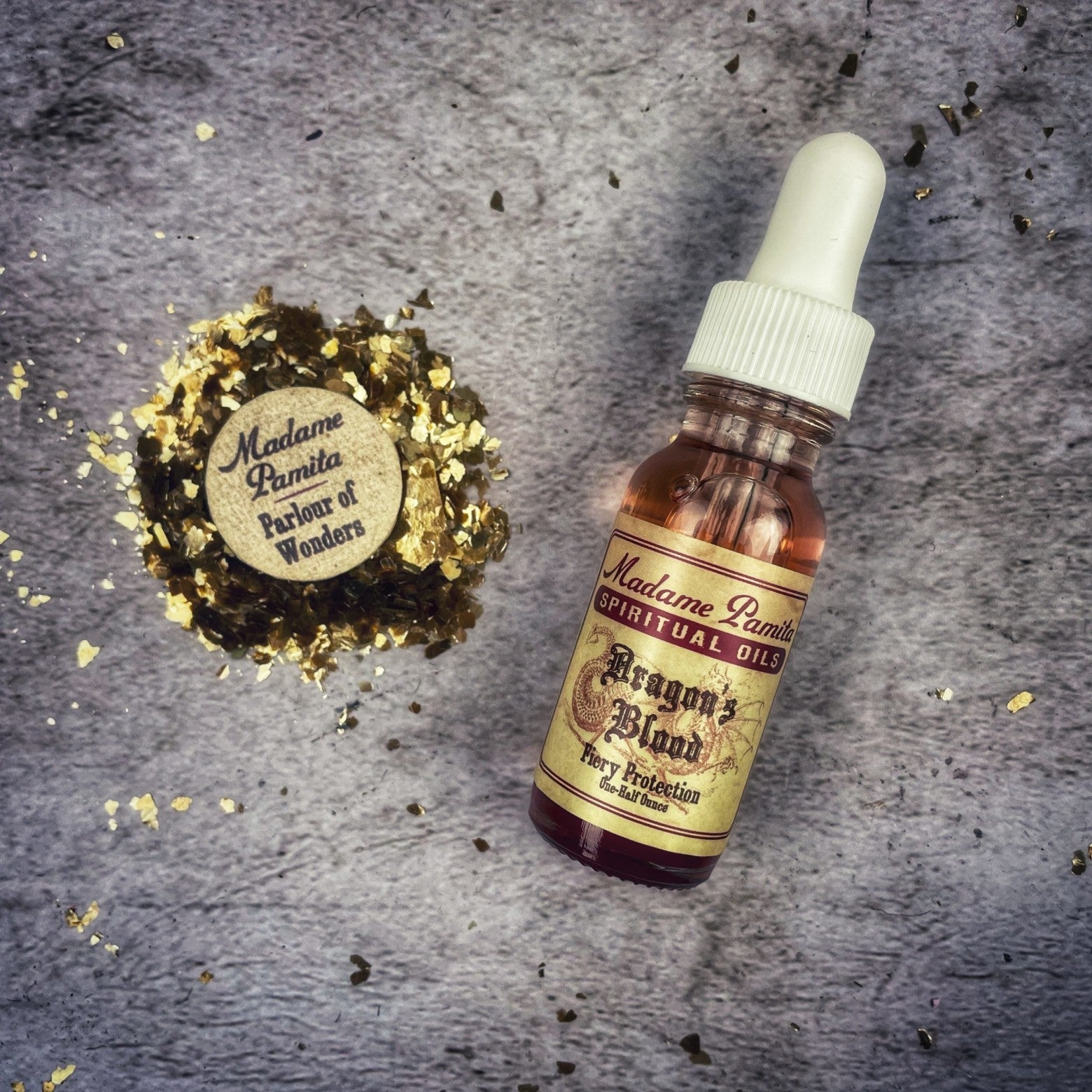 Dropper bottle of Dragons Blood Oil by Madame Pamita for mystical and spiritual use, with red liquid inside.