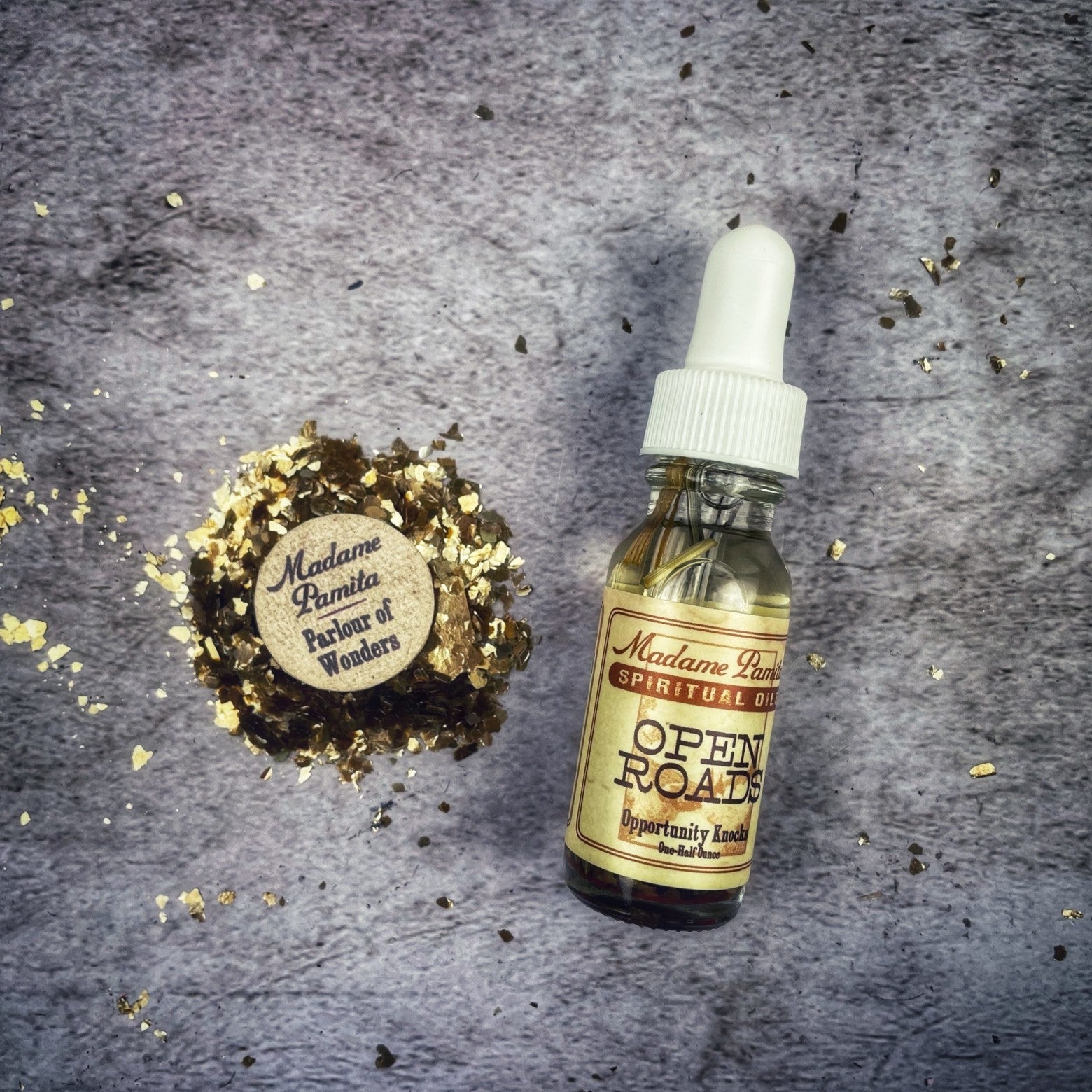 Open Roads Oil by Madame Pamita, a small glass bottle with a golden oil, used for spiritual or ritual purposes.