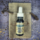 Bottle of Talk To Me Oil by Madame Pamita from Parlour of Wonders, featuring a dark glass bottle with a colorful label and dropper cap.