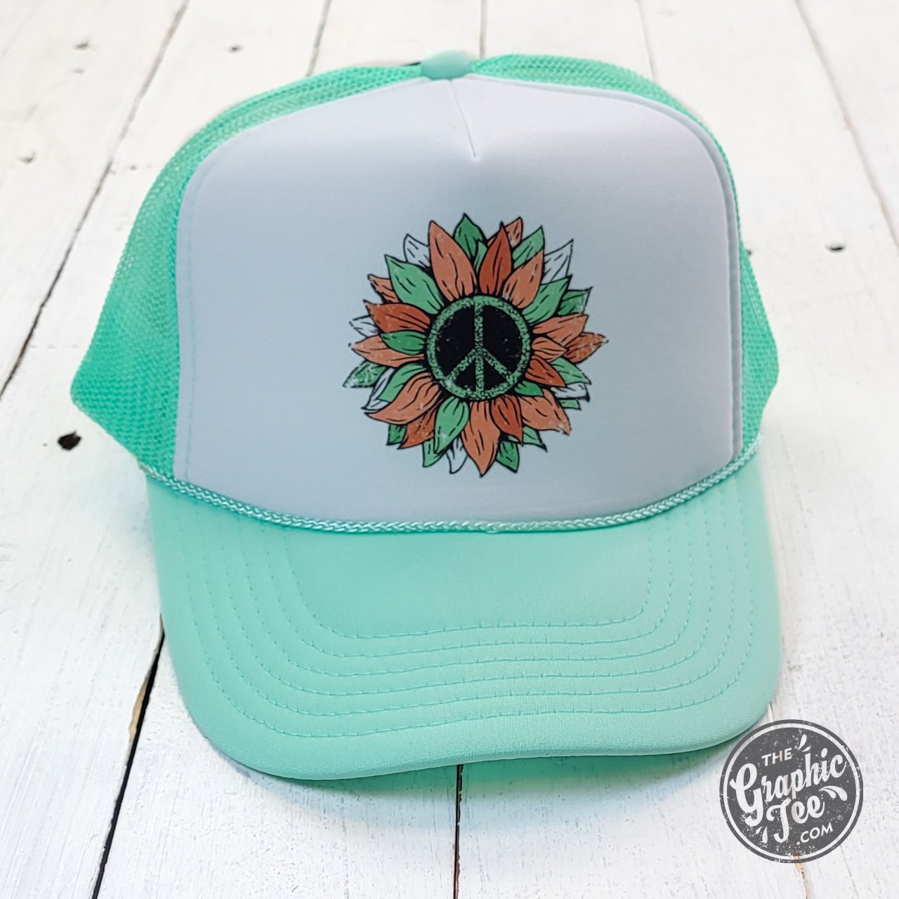 Seafoam and white foam trucker cap with peace sunflower design by The Graphic Tee, featuring adjustable mesh back and curved brim.