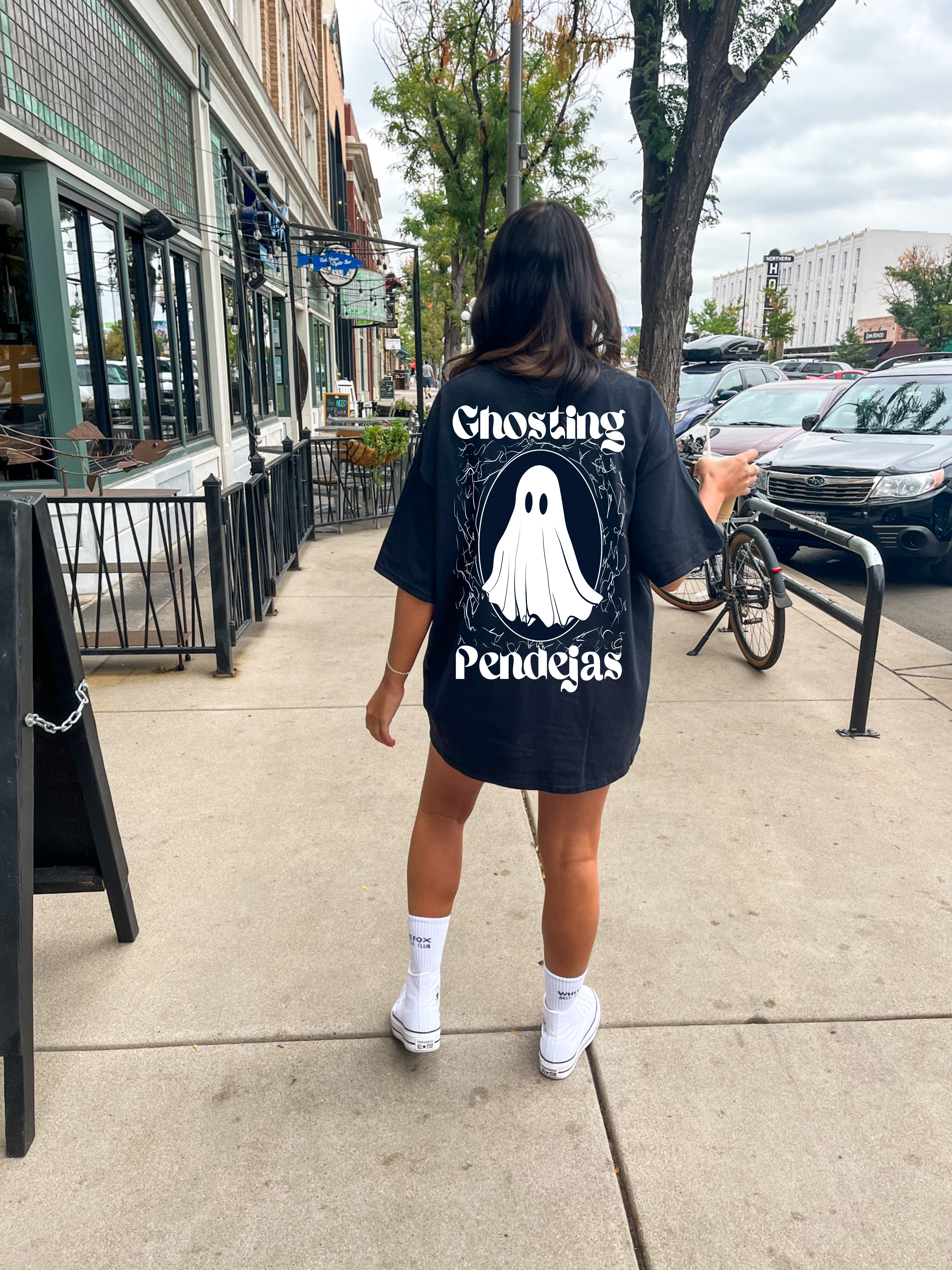 Ghosting Pendejas female graphic tee by Shop Karma Tees showing a stylish black T-shirt with colorful ghosting-themed artwork.