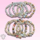 Pink Panache Brands faceted bead multi-strand bracelet stack with rhinestone cross, featuring blue beads and layered design.