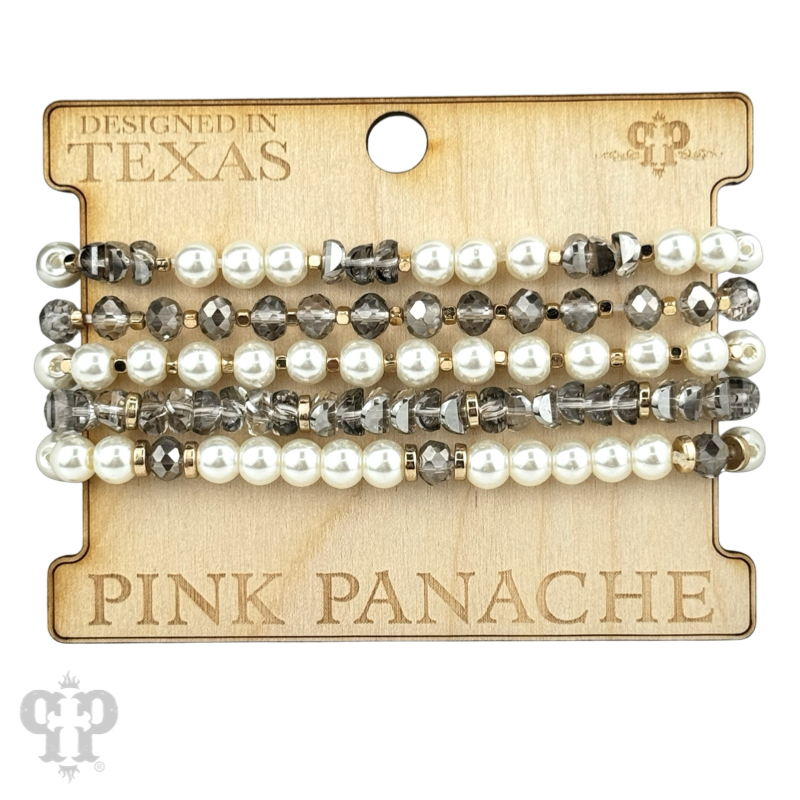 Stacked pink pearl and faceted bead bracelets by Pink Panache Brands, featuring gray pearls and shimmering beads.