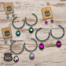 Silver Navajo style bead hoop earring with oval rhinestone charm, showcasing intricate beadwork and sparkling embellishments.