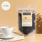 Plum Deluxe Porch Sippin' Pecan Black Tea in a clear tea container, showing rich dark tea leaves with pecan flavor accents.