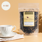 A jar of Plum Deluxe Peaches 'n' Cream Oolong Tea with peach and vanilla flavor, featuring dried tea leaves and fruit pieces.