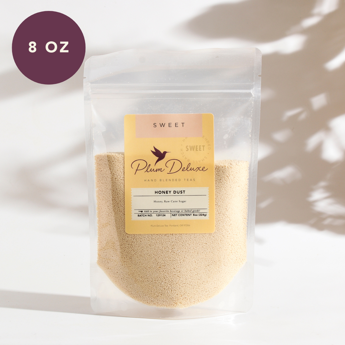 Plum Deluxe Honey Dust made from cane sugar and raw honey, shown in a 4 oz package with granulated texture.