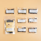 Assorted Plum Deluxe Tea Best Sellers Sampler Set with various caffeinated tea varieties in decorative packaging.
