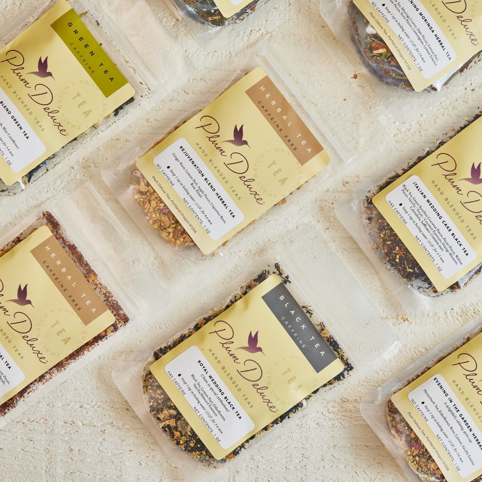 Plum Deluxe Tea Iced Tea Variety Pack with six flavors, featuring colorful bottles of caffeinated iced teas on a wooden table.