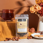 Black tea blend in a cup with cinnamon and hazelnut, showcasing Plum Deluxe's Autumn Vibes Black Tea flavor.