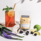 Blackberry Mojito Black Tea by Plum Deluxe, showing fresh blackberries, lime, maple, and spearmint in a brewed tea cup.